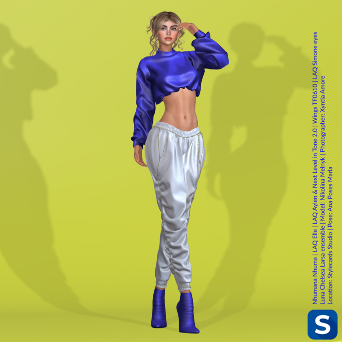 A full-length photo of Nikolina Melnyk posing in front of a bright yellow backdrop. She is wearing a long-sleeved blue crop top, white pants, and blue high heel boots.