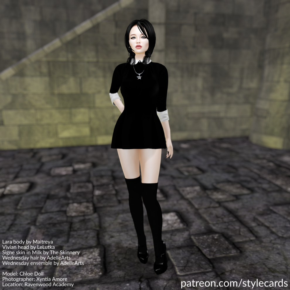 Chloe Doll stands in a black minidress accented by a white collar and white cuffs on the arms. For jewelry she has a necklace with a pentacle as a pendant. The ensemble is completed by black high-heels worn over black kneehighs.