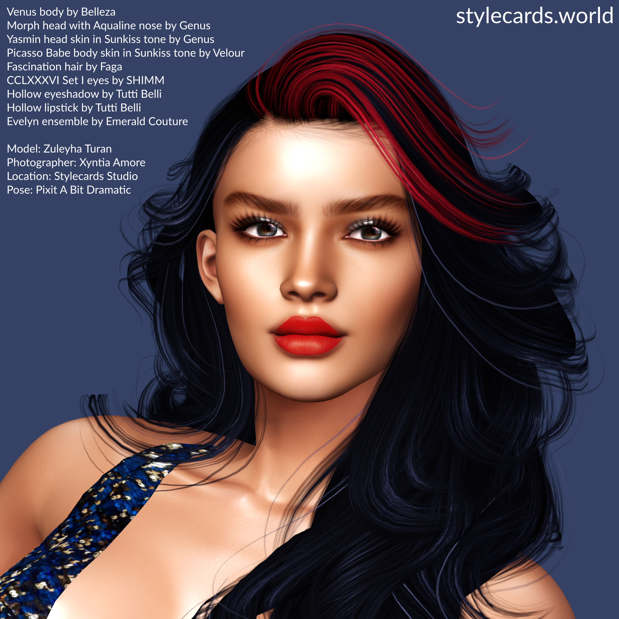 A closeup of Zuleyha Turan standing in front of a blue background which compliments her dark blue clothes. She has long wavy black hair with red streaks. She is wearing bright red lipstick and smoky eyeshadow.