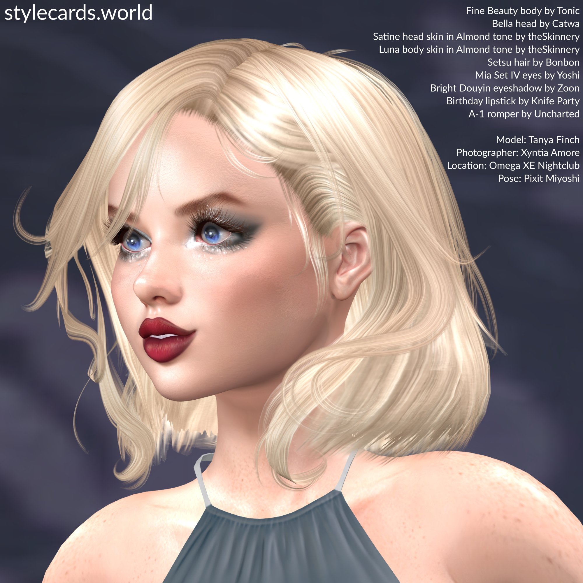 A closeup photo of Tanya Finch shows her looking off to her right while smiling about something. She has dark red lipstick and smokey silver-and-grey eyeshadow.