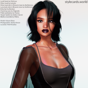 Kalyani Bose poses in front of a white background in a photo booth in the skating rink are a of Mall Paradise in Second Life. She is wearing dark red lipstick, smoky eyeshadow, a black tank top, and a sheer black jacket.