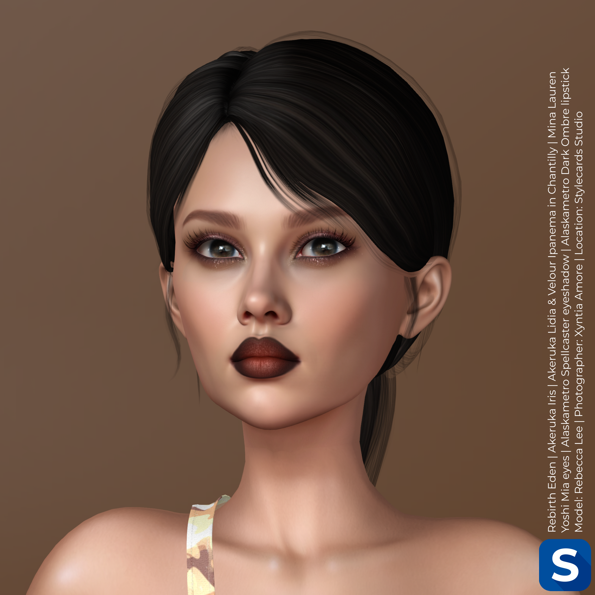 A headshot of Rebecca Lee shows her standing in front of a tan background and has a desert camo strap of fabric work around her right shoulder. She has long black hair done in a ponytail, smoky eyeshadow and dark lipstick.