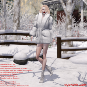 Janneke Peters is wearing a white fur coat and white boots, but most of her legs are bare. She is walking in a snowy area during daytime. In the background are cottages, trees, and fences that are all partially covered by snow.