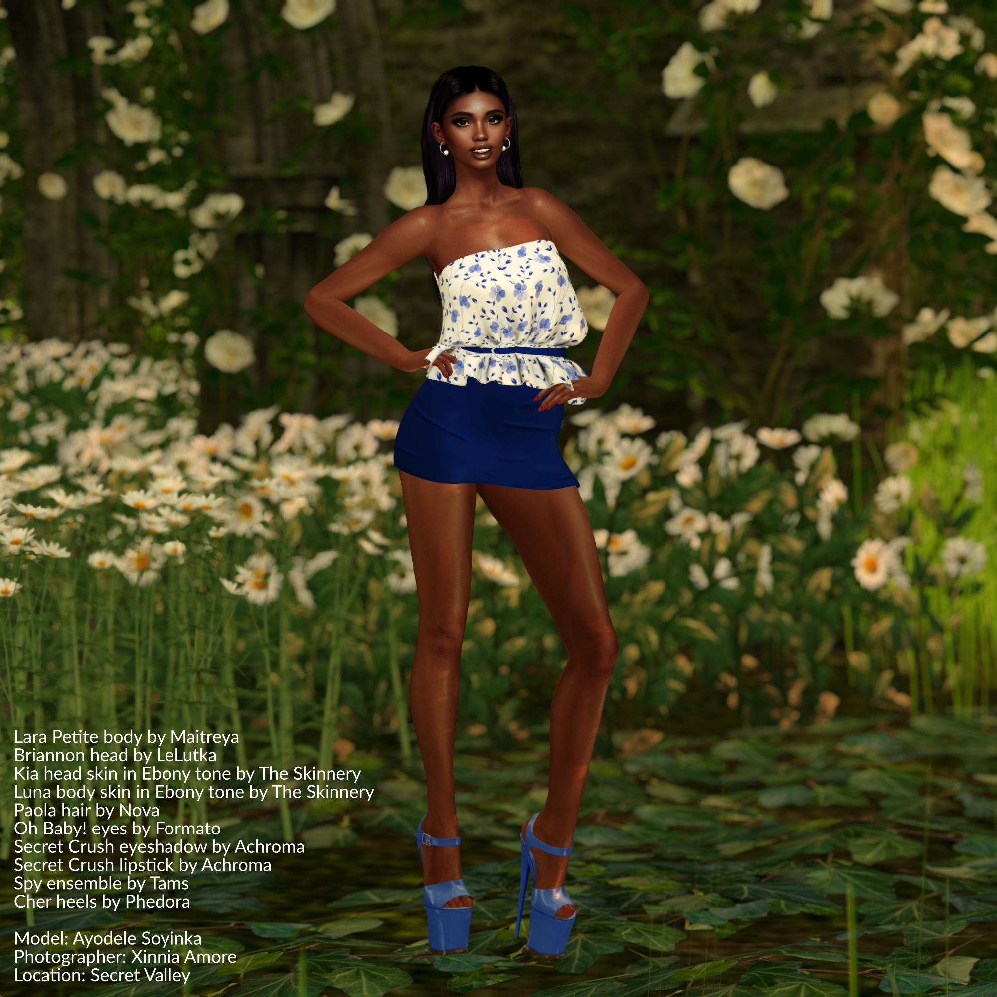 Ayodele Soyinka is standing in a field of wildflowers while wearing a floral blue-and-white blouse and a blue miniskirt, both from Tams, and blue high heels from Phedora.