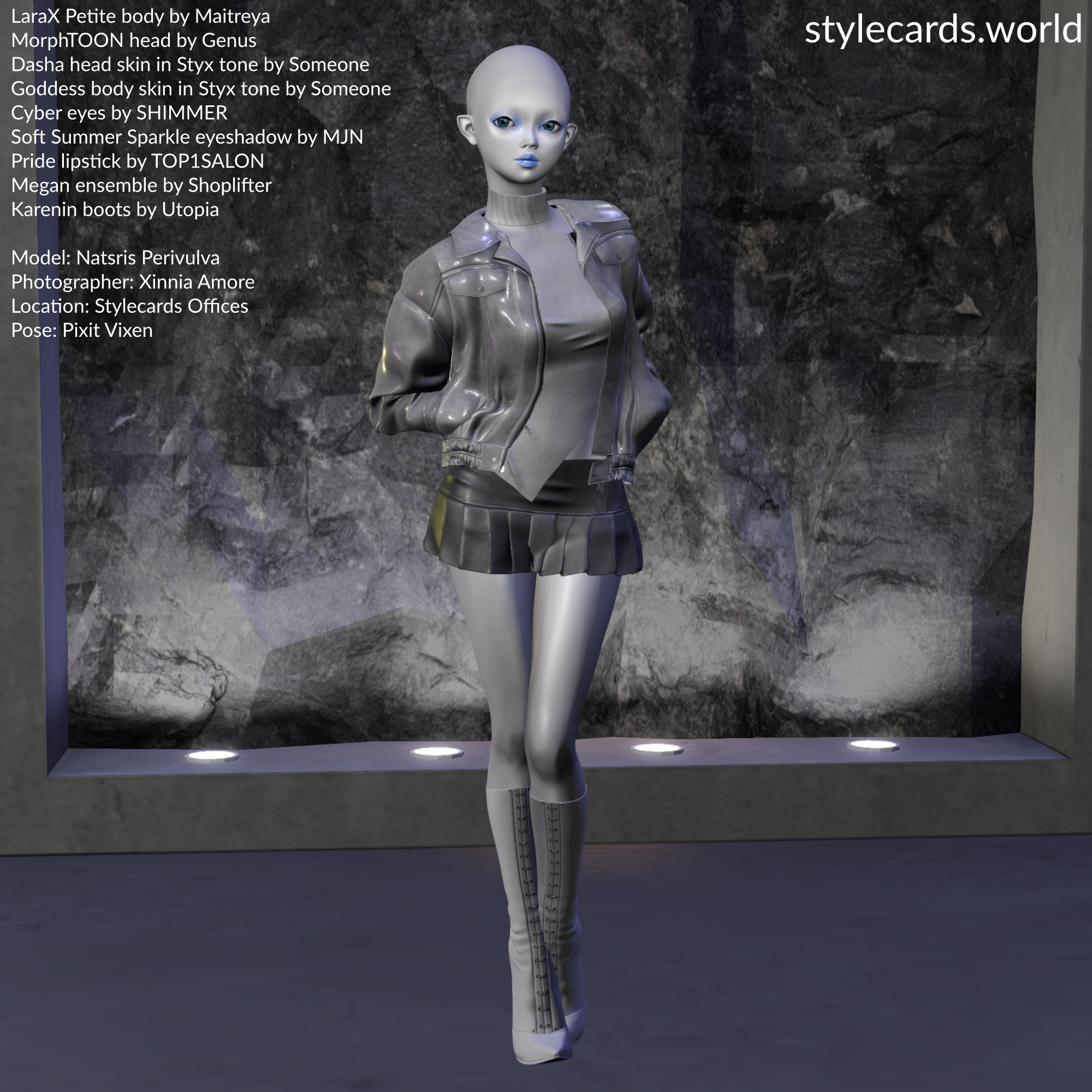 Natsris Perivulva is a grey-skinned alien from Mars, who lacks any hair, but has slightly pointy ears. She is wearing an asymmetric sweater, leather jacket, pleated skirt, and high-heeled boots, all in grey to match her skin. She is standing in front of a grey rock face while standing on a grey concrete floor.