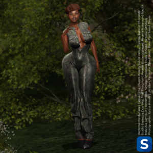 A photo of Pamela Hathaway wearing a camo jumpsuit while standing in front of some bushes. She has black shoes on her feet and a brown beret on her head.