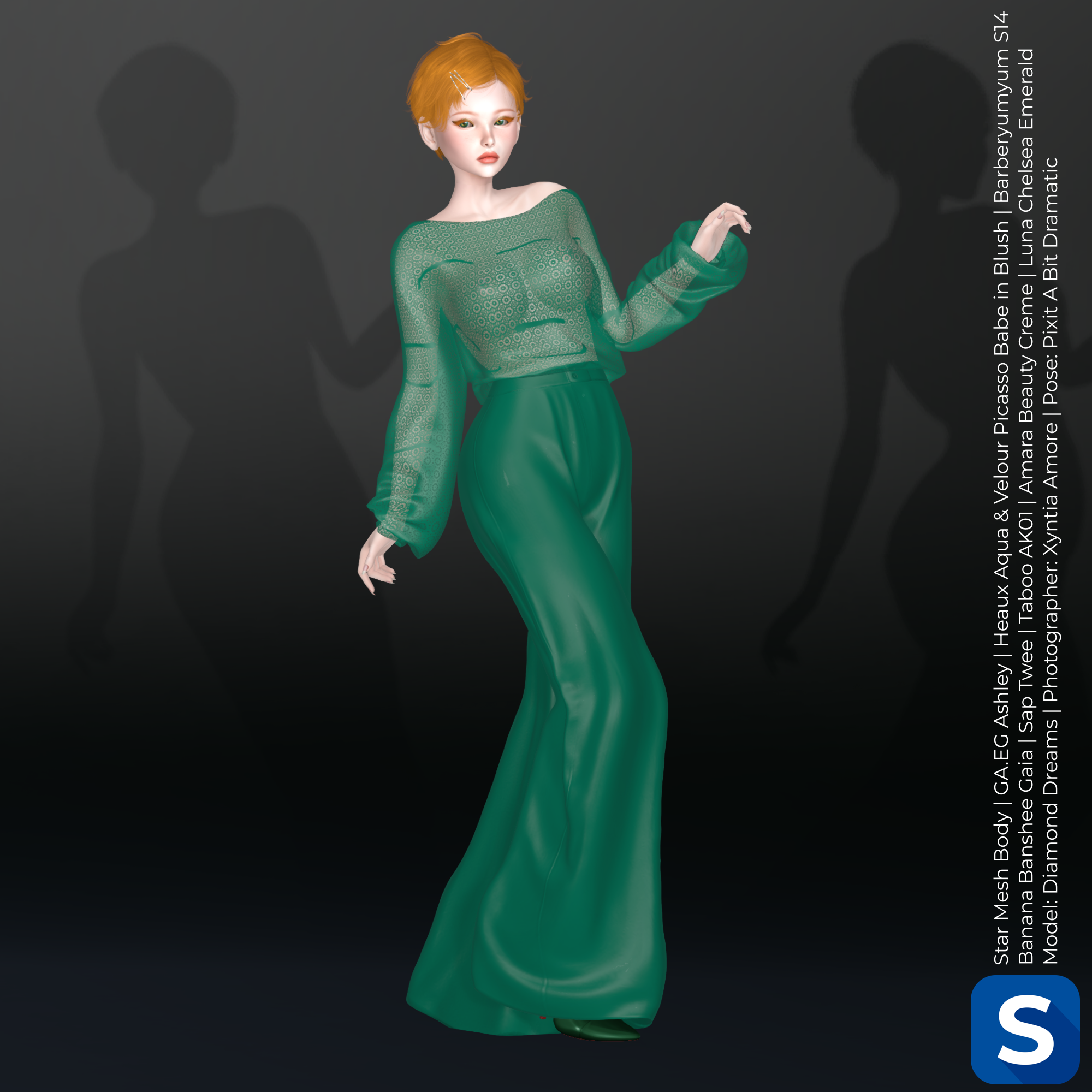 Diamond Dreams poses in a green ensemble featuring a lace blouse and satin pants. Her hair is short and bright red, and she is standing in front of a black backdrop.