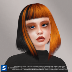 A headshot of a female model standing in front of a light beige backdrop. Her short hair is half-black and half-orange, which complement her black blouse and her orange lipstick and eyeshadow.