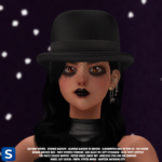 A headshot of a woman standing in front of a dark purple backdrop with white dots on it. Her long black hair is draped over her collarbones onto the front of her black sleeveless romper. Atop her head is a black felt Derby hat with black mesh extending beneath the brim in front of her face. Her golden eyes are surrounded by inky black eyeshadow and her lips are marked with glossy black lipstick.